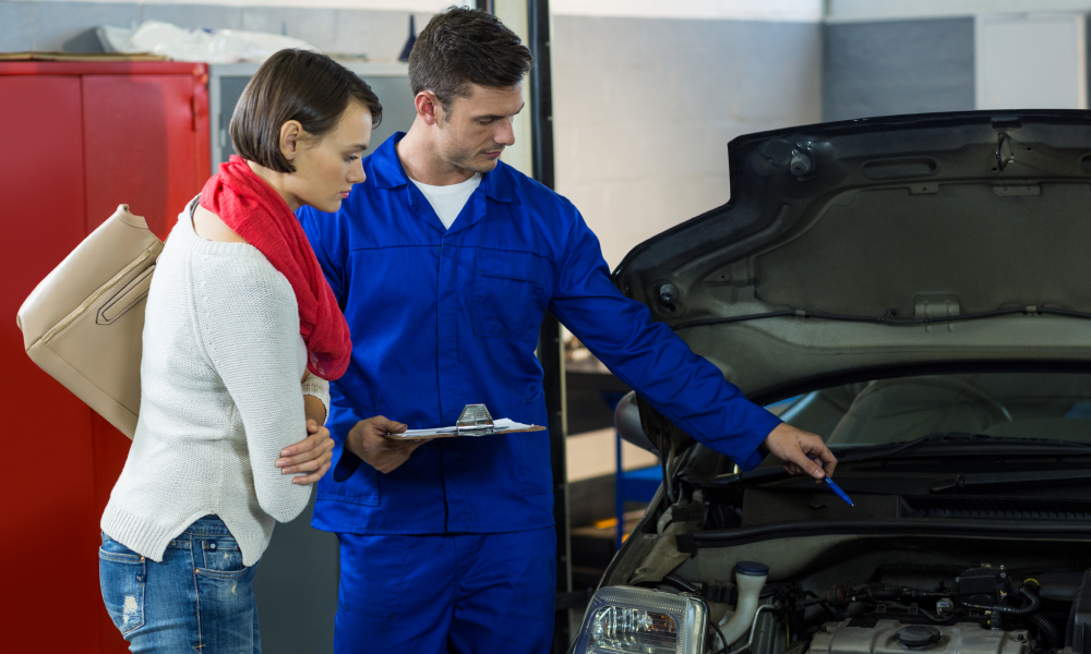 An engineer showing a customer car under hood